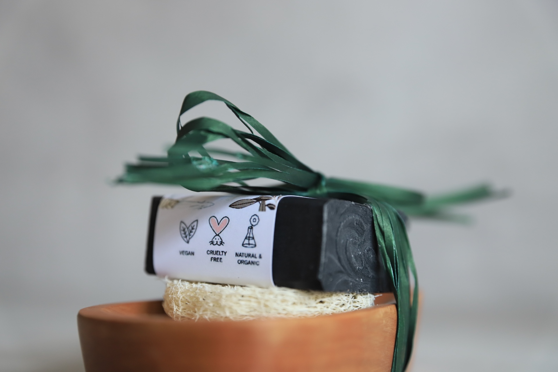 Svart tvål med vitt omslag där symbolerna för vegan, cruelty free och natural & organic syns, symboler som inte längre får användas.
